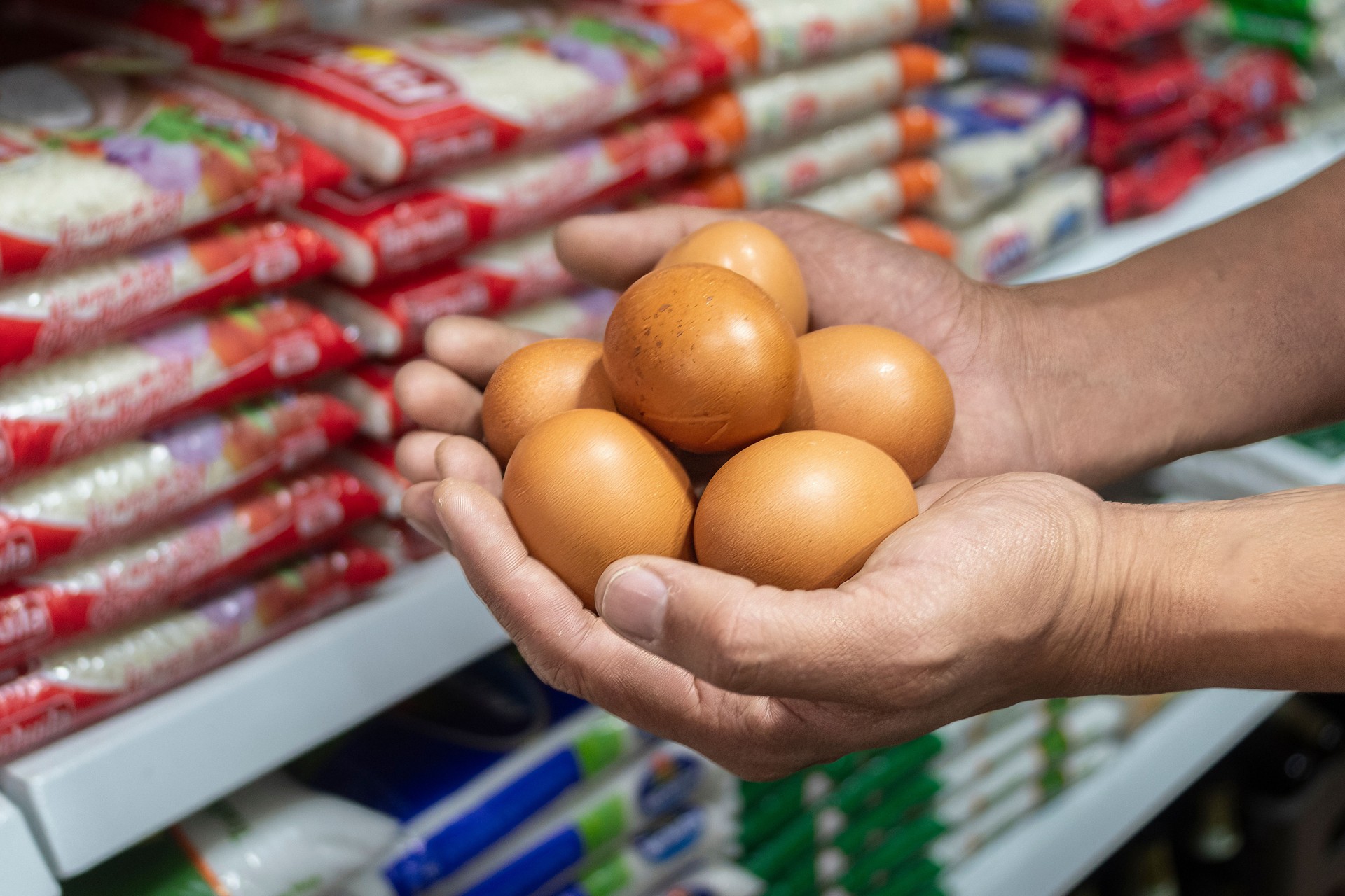 Man's hands with eggs in the store